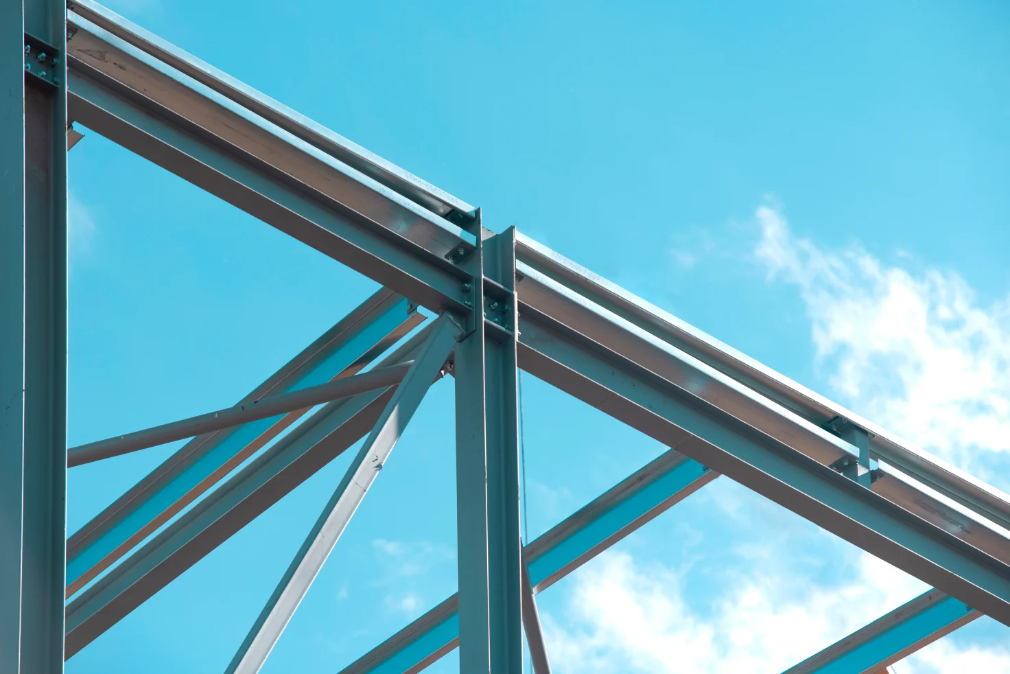 Close-up view of a steel frame structure under a clear sky, illustrating durable and precisely engineered beams supplied by a reliable structural steel supplier in Singapore.